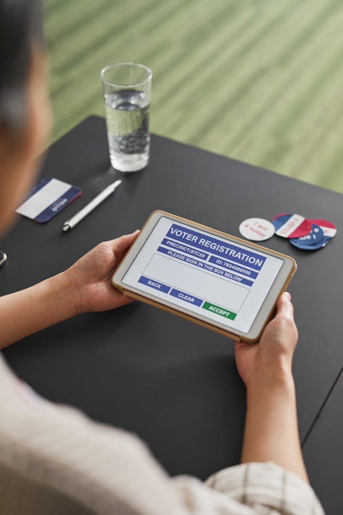 Individual using digital tablet for online voter registration at home.
